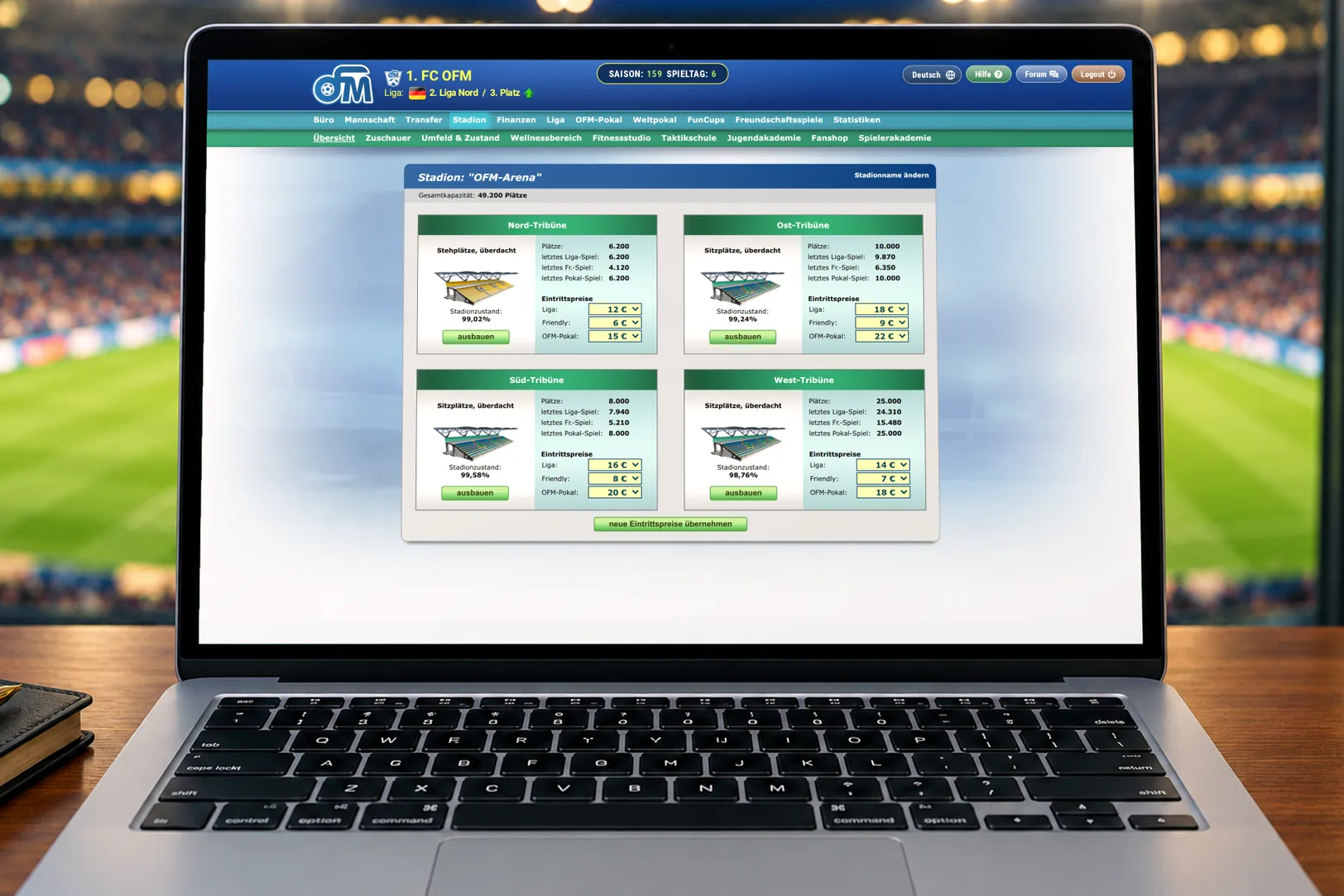 Laptop mit dem Stadionausbau im OFM: vier Tribünen mit Plätzen, Zuschauern und Eintrittspreisen